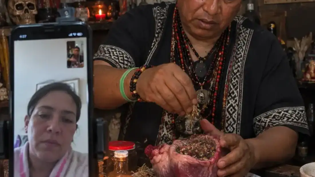 Altar de curanderos con velas rojas, hierbas y ofrendas